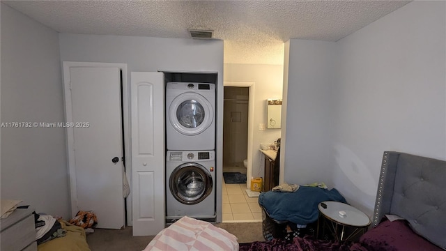 washroom with visible vents, carpet floors, laundry area, stacked washing maching and dryer, and a textured ceiling