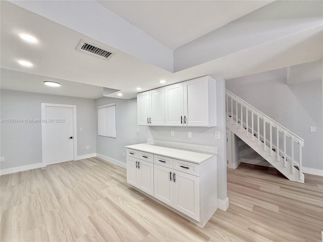 kitchen featuring visible vents, baseboards, light wood-style flooring, and light countertops