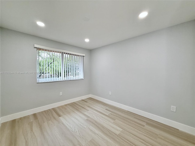 empty room featuring recessed lighting, light wood-style flooring, and baseboards