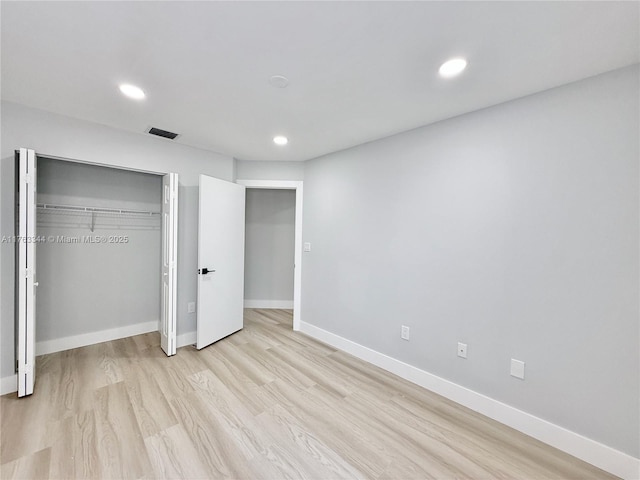 unfurnished bedroom featuring light wood finished floors, visible vents, baseboards, recessed lighting, and a closet