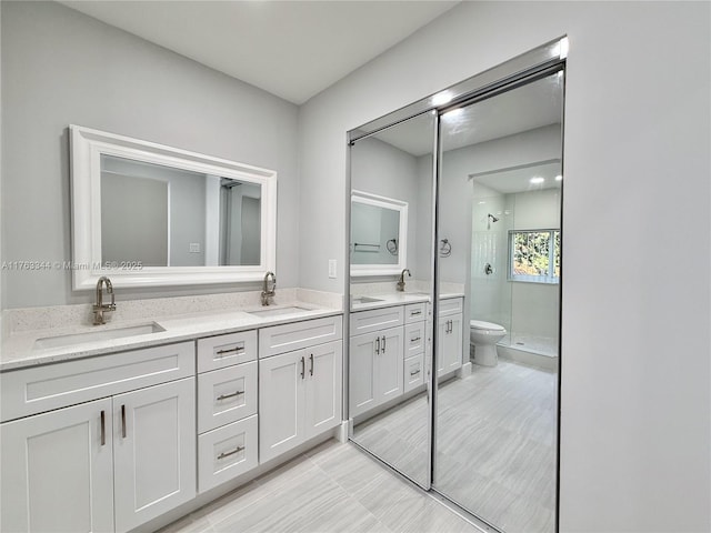 full bath featuring a sink, toilet, double vanity, and a shower stall