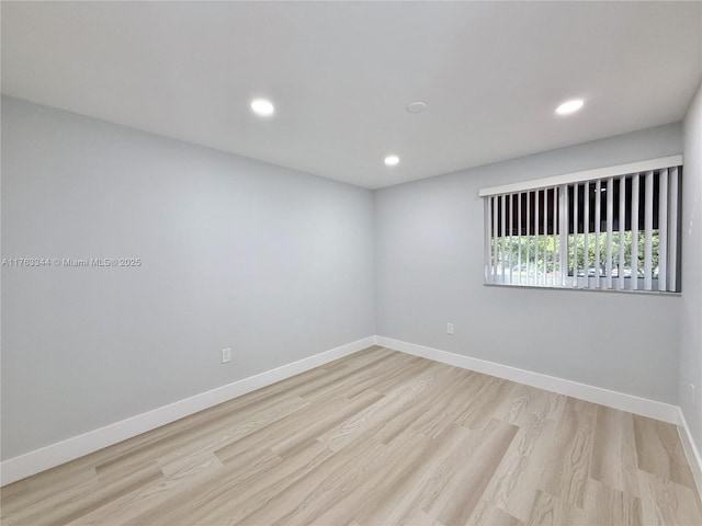 empty room with recessed lighting, light wood-type flooring, and baseboards