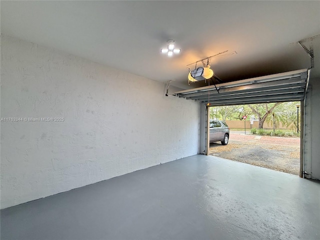 garage with a garage door opener and a textured wall