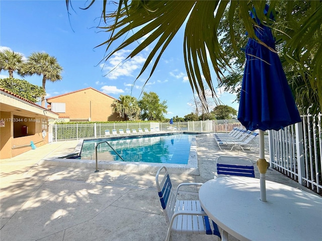 community pool featuring a patio and fence