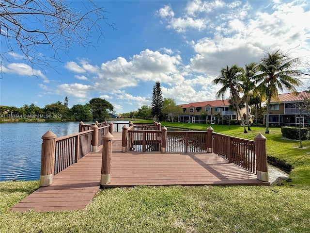 dock area featuring a deck with water view and a lawn