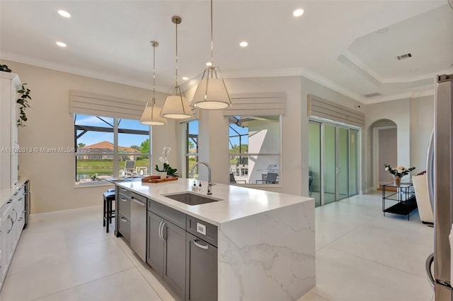 kitchen featuring crown molding, a center island with sink, recessed lighting, stainless steel appliances, and a sink