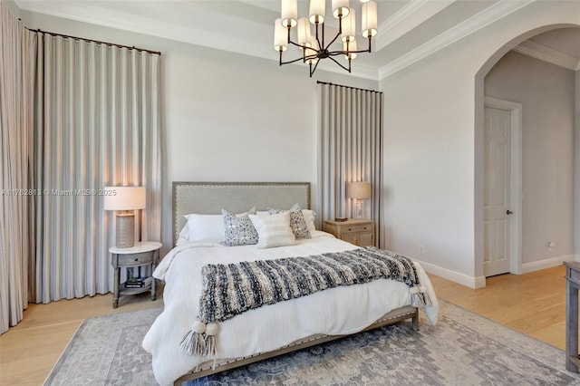 bedroom with arched walkways, a notable chandelier, wood finished floors, and crown molding