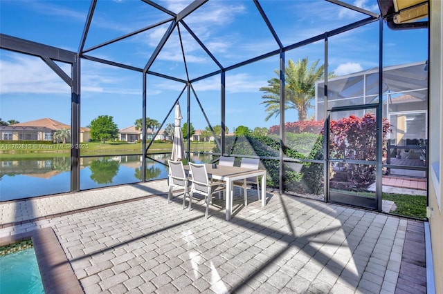 view of patio with glass enclosure and a water view