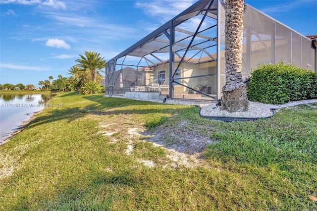 view of yard featuring glass enclosure and a water view