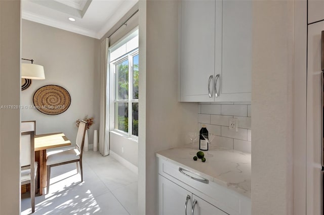 bar featuring tasteful backsplash, crown molding, and baseboards