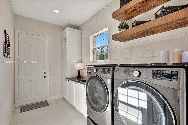 washroom featuring washer and clothes dryer, recessed lighting, cabinet space, light tile patterned floors, and baseboards