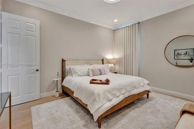 bedroom with light wood finished floors, recessed lighting, crown molding, and baseboards