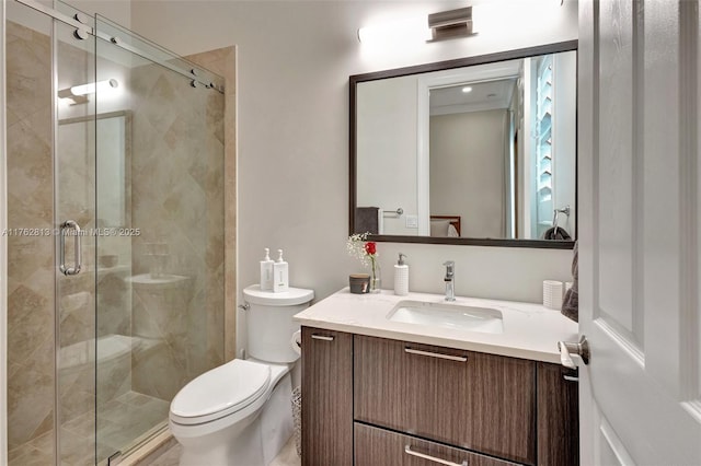 bathroom with a stall shower, toilet, and vanity