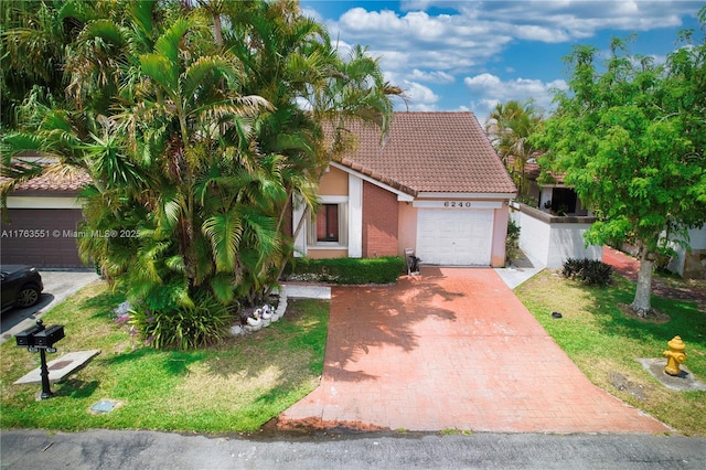 6240 NW 176th Ter, Hialeah, FL 33015 - view of front of home with a tiled roof, a front lawn, stucco siding, decorative driveway, and a garage
