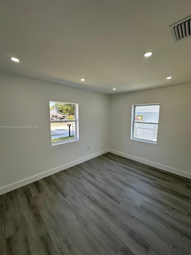 unfurnished room featuring a healthy amount of sunlight, visible vents, and baseboards