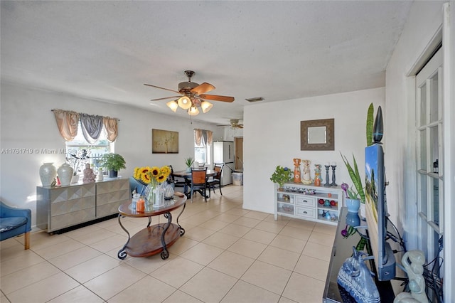 interior space featuring a wealth of natural light, visible vents, light tile patterned flooring, and a ceiling fan