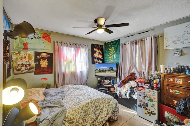 bedroom featuring tile patterned flooring, a ceiling fan, and a textured ceiling