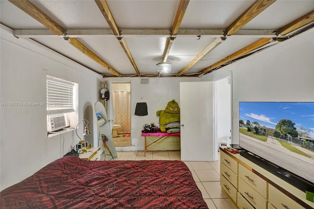 bedroom featuring ensuite bath, light tile patterned floors, and cooling unit