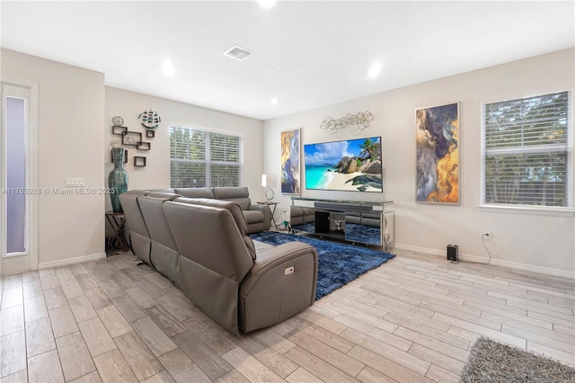 living area featuring visible vents, recessed lighting, baseboards, and light wood-style floors