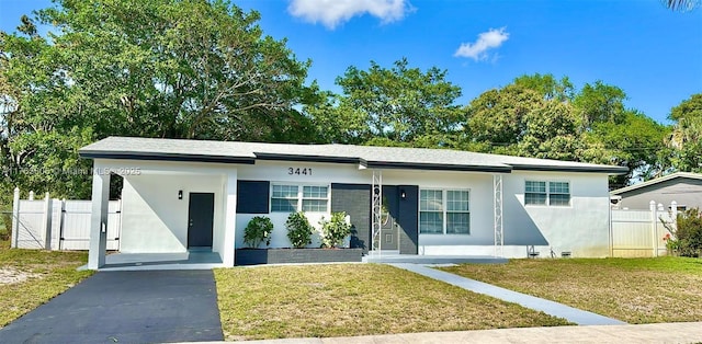 view of front of house featuring stucco siding, fence, a front lawn, and a gate