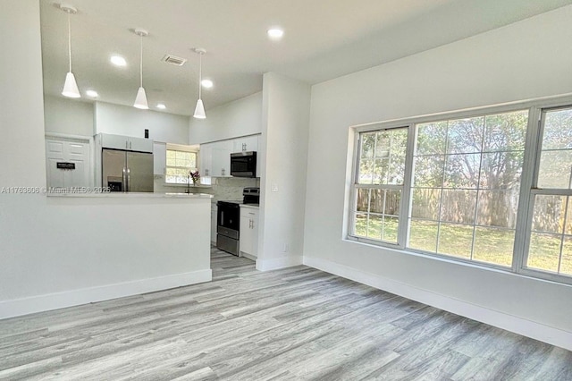 kitchen featuring white cabinetry, light wood finished floors, baseboards, and appliances with stainless steel finishes