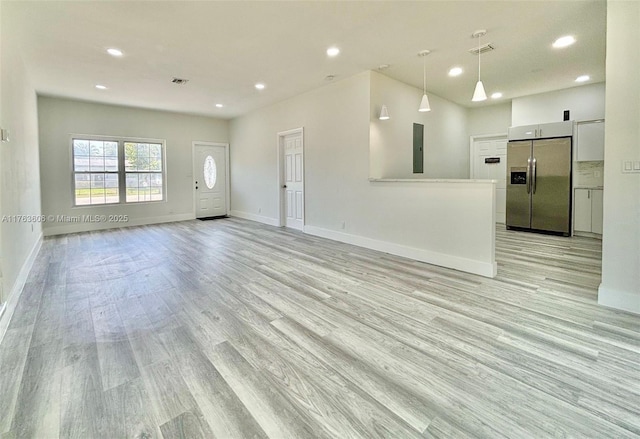 unfurnished living room with recessed lighting, baseboards, and light wood finished floors