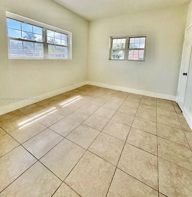 spare room with tile patterned floors and baseboards