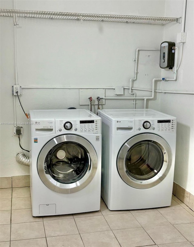 clothes washing area with light tile patterned floors, laundry area, and washer and dryer