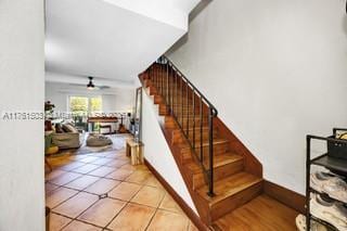 stairs with tile patterned floors and a ceiling fan