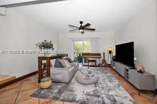 living area featuring baseboards and a ceiling fan