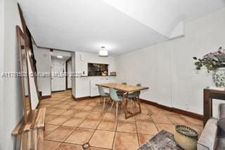 dining space featuring light tile patterned floors and baseboards