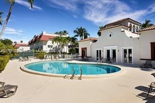 pool featuring french doors, a patio, and fence