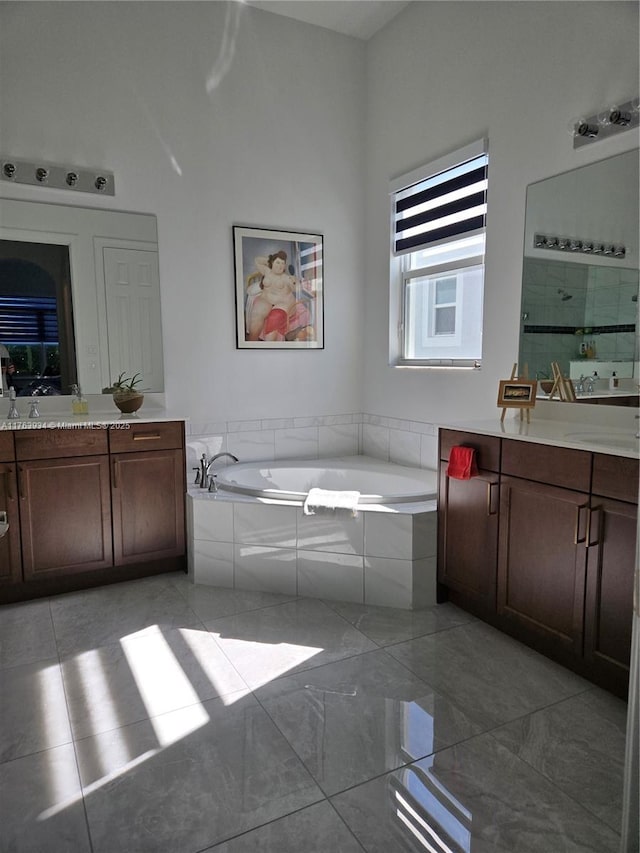 full bathroom featuring two vanities, a bath, and tiled shower