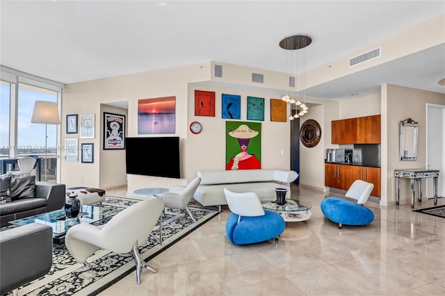 living area featuring baseboards, visible vents, and floor to ceiling windows