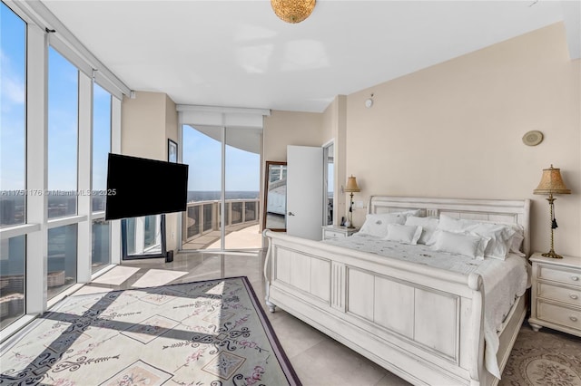 bedroom with access to outside, tile patterned flooring, multiple windows, and a wall of windows