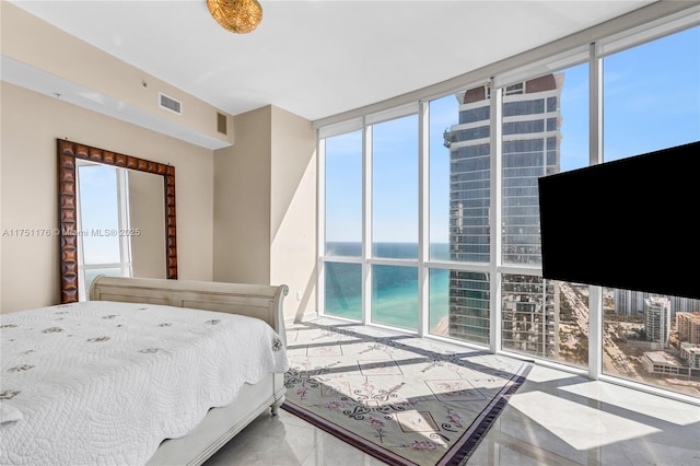 bedroom featuring multiple windows, visible vents, and floor to ceiling windows