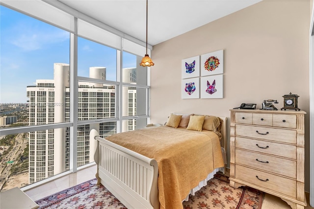 bedroom featuring expansive windows and a view of city