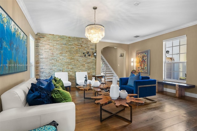 living room featuring hardwood / wood-style floors, crown molding, visible vents, and arched walkways