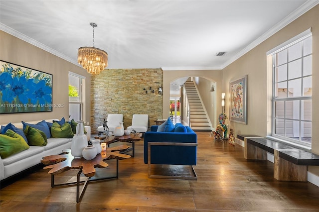 living area with a notable chandelier, visible vents, crown molding, and wood-type flooring