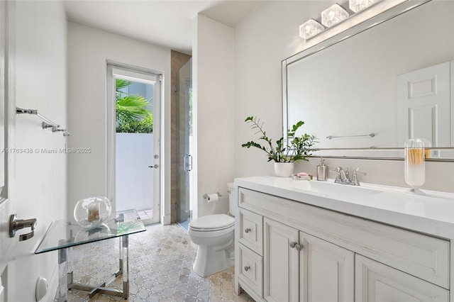 bathroom featuring vanity, a shower stall, and toilet