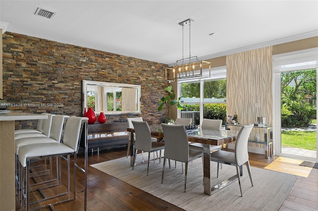 dining space featuring visible vents, wood-type flooring, and a notable chandelier