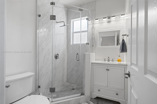 bathroom featuring a marble finish shower, toilet, and vanity