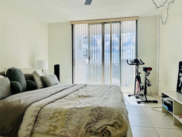 tiled bedroom featuring access to outside, floor to ceiling windows, and a textured ceiling