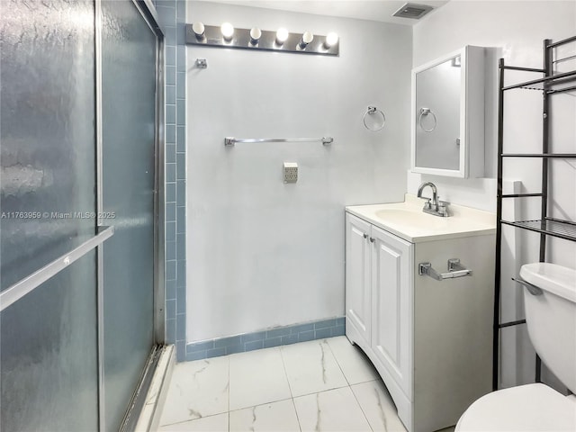 full bathroom with vanity, a shower stall, toilet, and visible vents