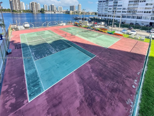 view of sport court featuring shuffleboard, a view of city, and a water view