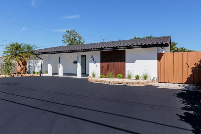 view of front of house featuring a tile roof and fence