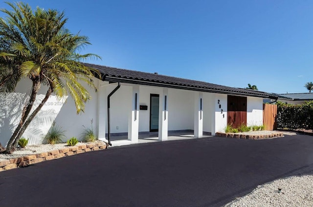 ranch-style house featuring stucco siding and a tiled roof