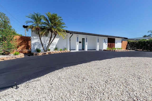 ranch-style home with stucco siding and fence