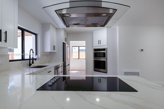 kitchen with white cabinets, visible vents, stainless steel appliances, and a sink