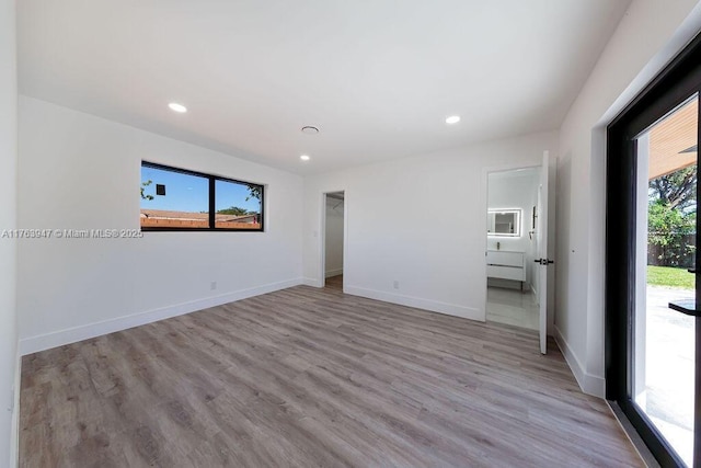 unfurnished room with recessed lighting, light wood-type flooring, and baseboards